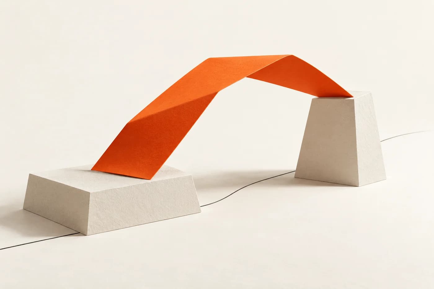 Eine gefaltete orangefarbene Papierbrücke überspannt zwei elfenbeinfarbige Stützen; eine feine dunkle Linie begleitet die Spanne.